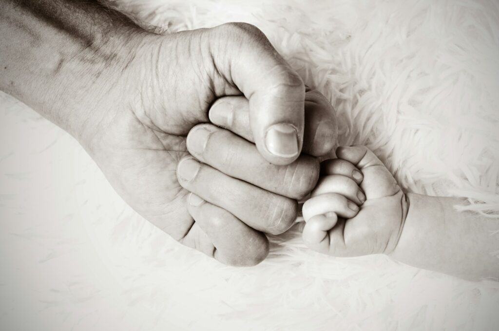 what makes a good foster carer
a close up of a person fist-bumping a baby's hand